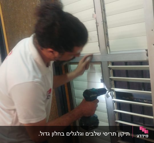 אדם מתקין תריסים עם מברגה חשמלית